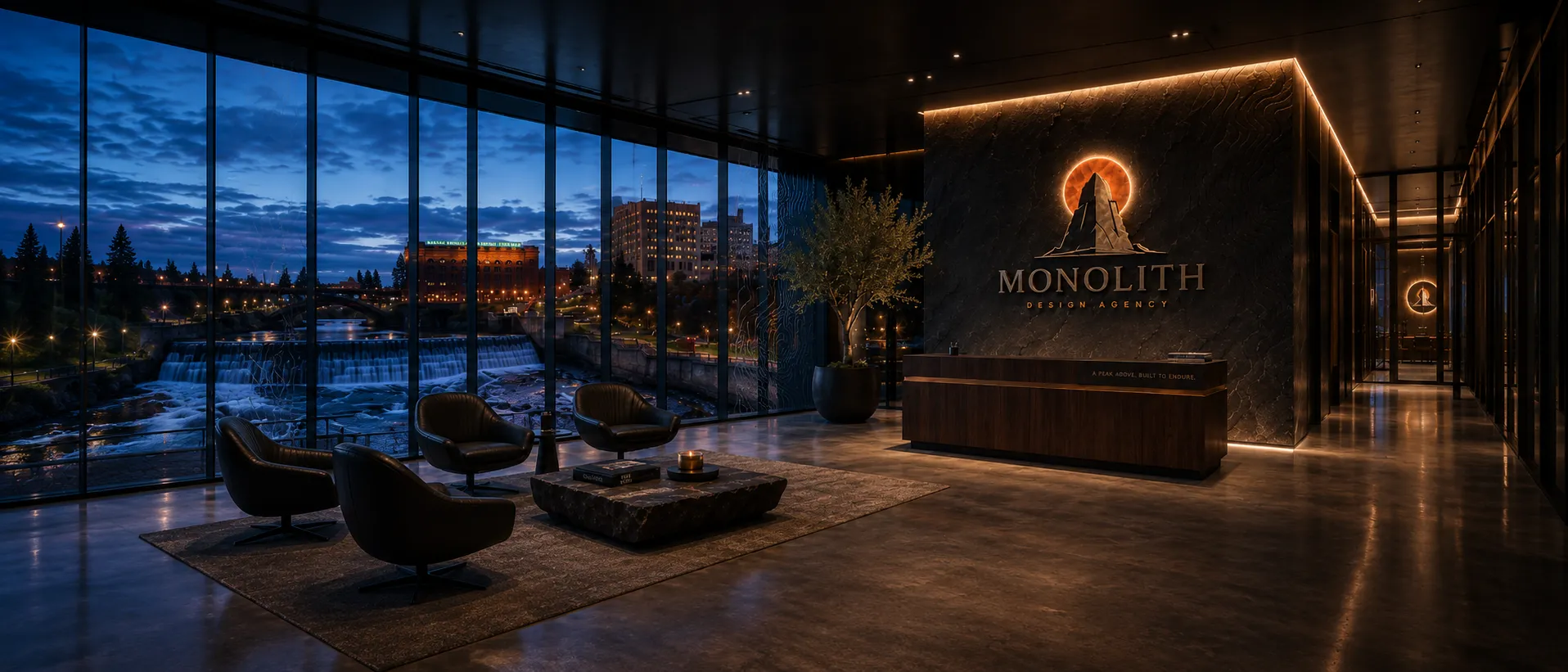 The Monolith lobby and logo wall at dusk, city skyline through floor-to-ceiling windows